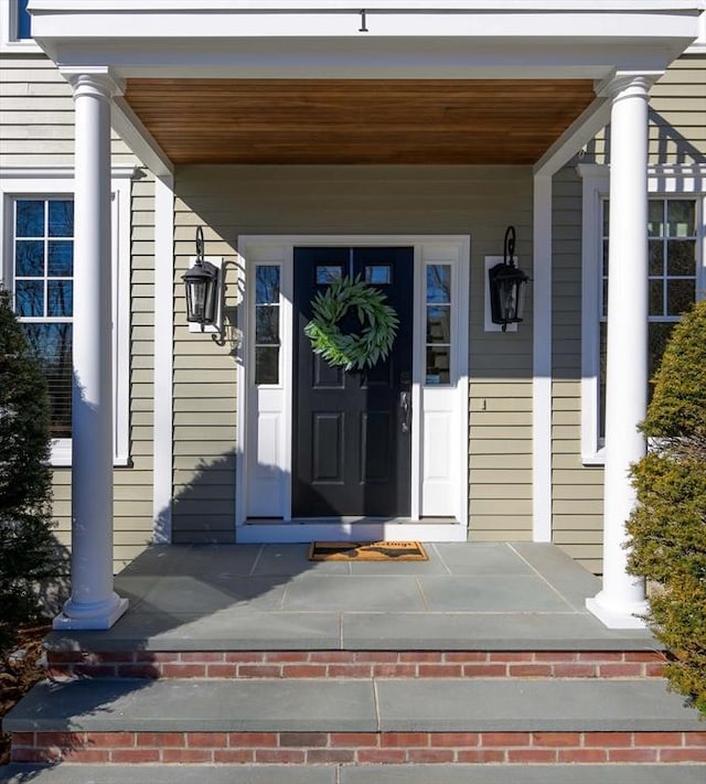 entrance to property featuring brick siding and a porch