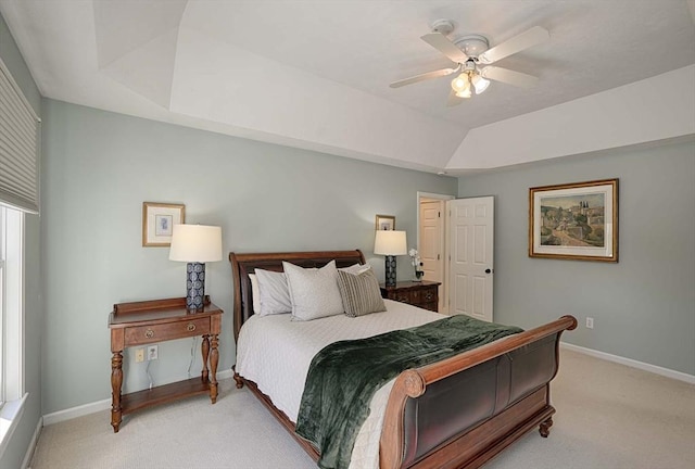 carpeted bedroom with ceiling fan, baseboards, and a tray ceiling