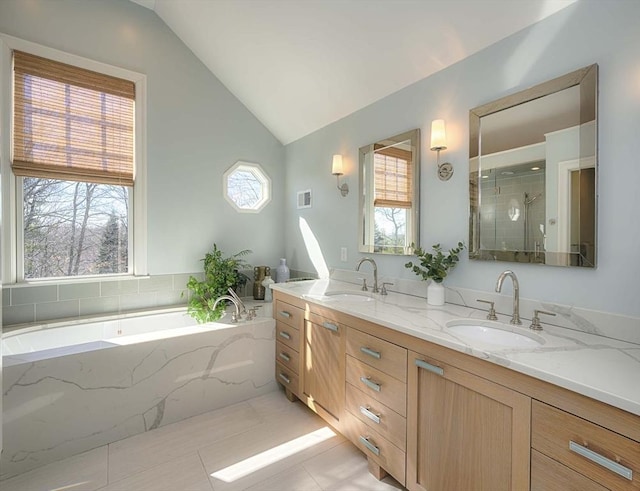 full bath featuring a sink, double vanity, a shower stall, and vaulted ceiling