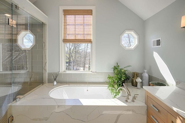 full bathroom with visible vents, vaulted ceiling, a stall shower, a bath, and vanity