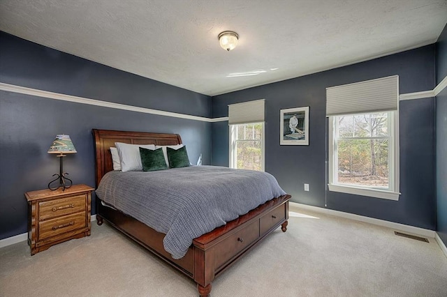 bedroom with multiple windows, light colored carpet, and baseboards