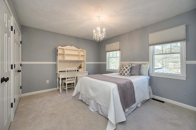 bedroom featuring baseboards, visible vents, light carpet, and an inviting chandelier