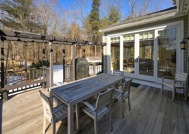 wooden terrace featuring outdoor dining space and area for grilling