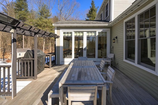 deck with outdoor dining space, french doors, a pergola, and a grill