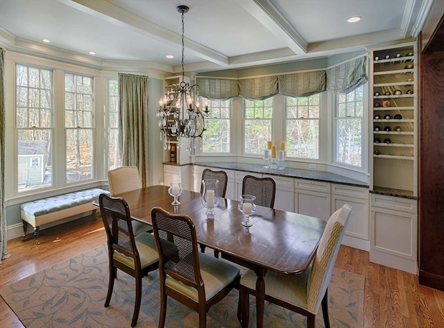 dining room featuring light wood finished floors, beamed ceiling, an inviting chandelier, and ornamental molding