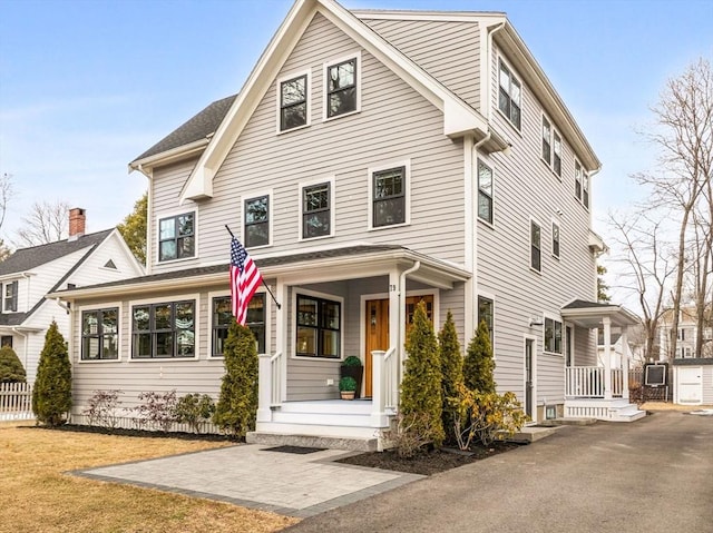 view of front of property with a porch and fence