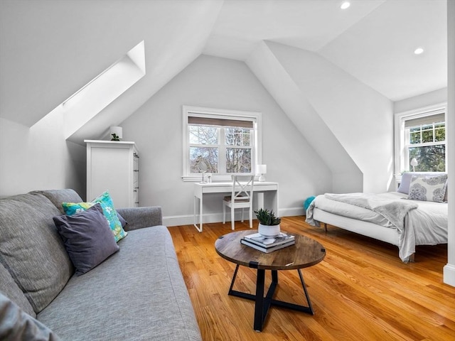 bedroom featuring lofted ceiling with skylight, recessed lighting, light wood-style flooring, and baseboards