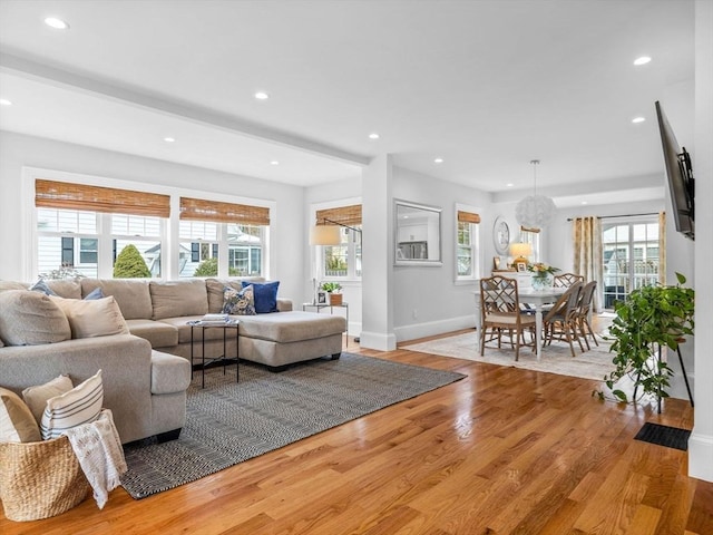 living room featuring recessed lighting, baseboards, and light wood finished floors