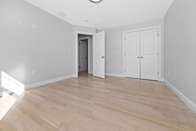 unfurnished bedroom featuring a closet and light wood-type flooring