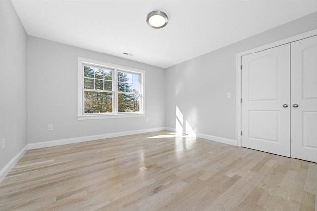 unfurnished bedroom featuring light hardwood / wood-style flooring and a closet