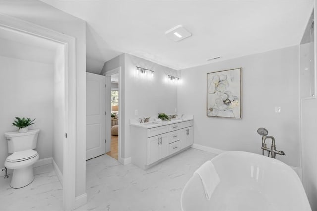 bathroom featuring vanity, a tub, and toilet