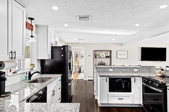 kitchen featuring black appliances, light stone counters, a baseboard radiator, and a sink