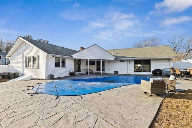 view of pool with a covered pool, a patio, and fence