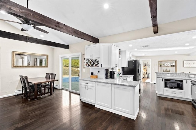 kitchen with white cabinetry, light stone counters, dark wood-style floors, and built in microwave