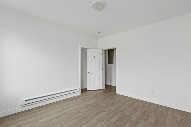 spare room with baseboard heating and light hardwood / wood-style floors