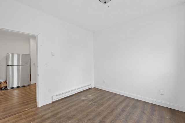 empty room featuring dark wood-type flooring and a baseboard radiator