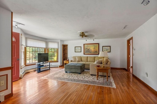 344 Mayfair Rd, Dennis, MA 02660 - living room with wood-type flooring, track lighting, and a baseboard heating unit