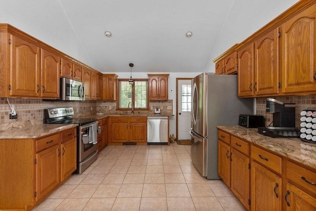 344 Mayfair Rd, Dennis, MA 02660 - kitchen with stainless steel appliances, lofted ceiling, brown cabinets, tasteful backsplash, and light stone countertops