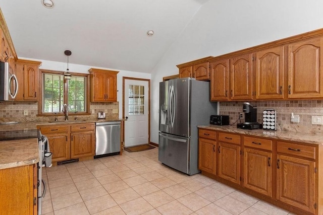 344 Mayfair Rd, Dennis, MA 02660 - kitchen with appliances with stainless steel finishes, lofted ceiling, backsplash, brown cabinets, and light tile patterned floors