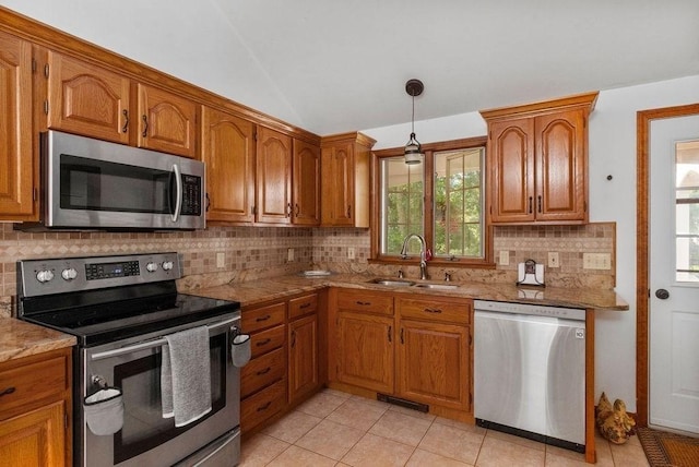 344 Mayfair Rd, Dennis, MA 02660 - kitchen featuring appliances with stainless steel finishes, brown cabinets, backsplash, lofted ceiling, and light tile patterned floors