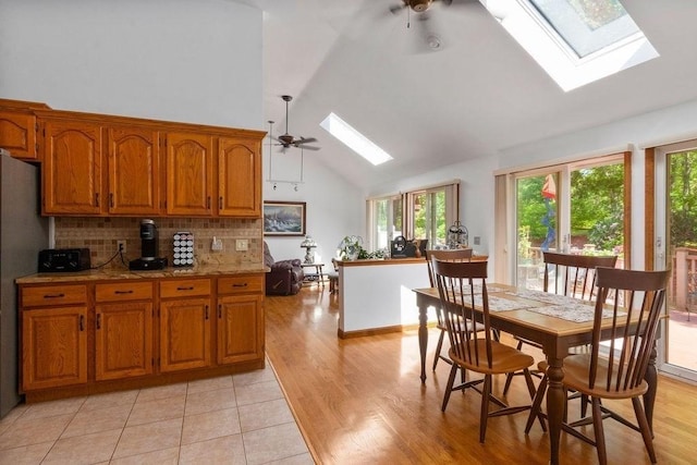 344 Mayfair Rd, Dennis, MA 02660 - kitchen with a skylight, plenty of natural light, brown cabinetry, ceiling fan, and high vaulted ceiling