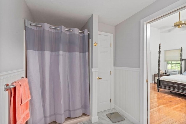344 Mayfair Rd, Dennis, MA 02660 - bathroom with wainscoting, wood finished floors, curtained shower, and a decorative wall