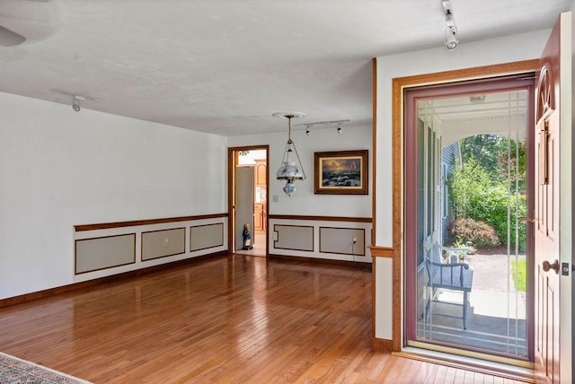 344 Mayfair Rd, Dennis, MA 02660 - foyer with rail lighting, wood finished floors, and a wainscoted wall