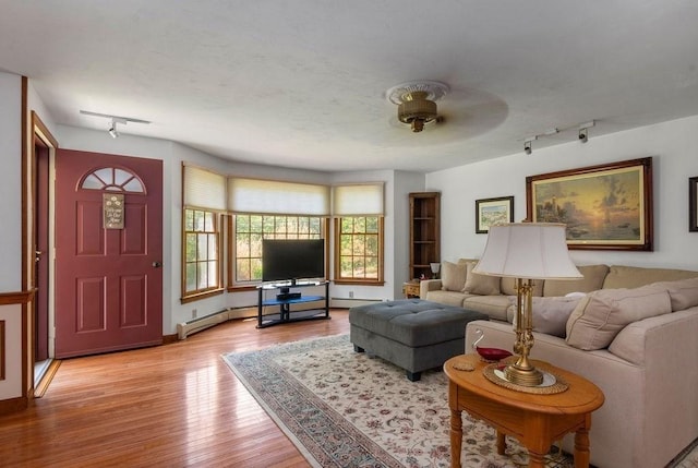 344 Mayfair Rd, Dennis, MA 02660 - living room with rail lighting, wood finished floors, and a baseboard radiator