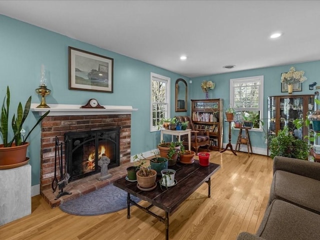 living area featuring recessed lighting, visible vents, wood finished floors, and a fireplace