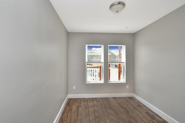 unfurnished room with dark wood-type flooring