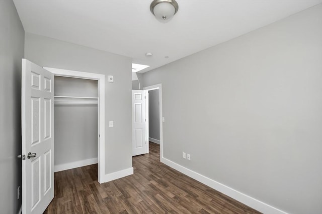 unfurnished bedroom featuring dark hardwood / wood-style flooring and a closet