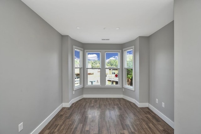 empty room with dark hardwood / wood-style flooring