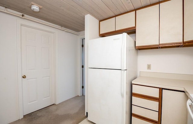 kitchen featuring white refrigerator, wooden ceiling, and white cabinets