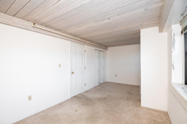 spare room featuring light carpet and wooden ceiling