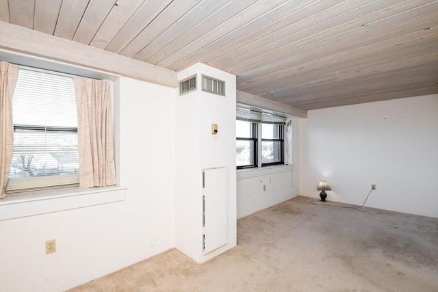 empty room featuring light carpet and wooden ceiling