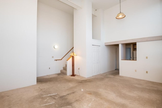 unfurnished living room with a towering ceiling