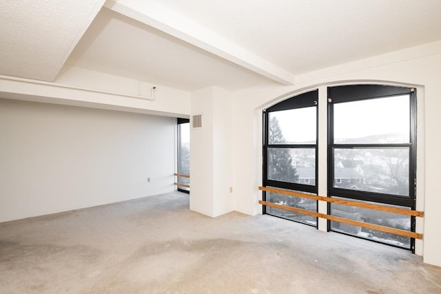 interior space featuring light colored carpet and beam ceiling