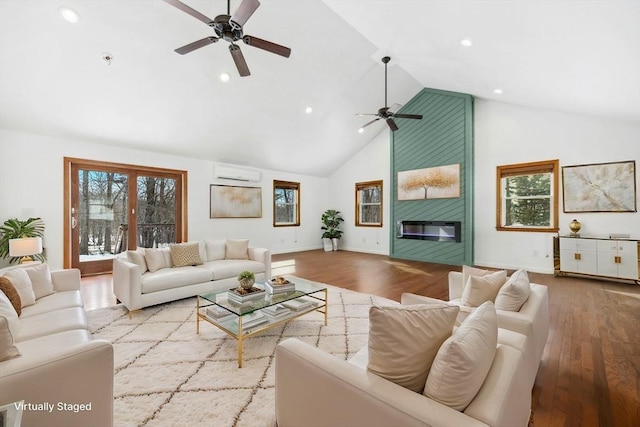 living area with light wood-style floors, a wall mounted air conditioner, a fireplace, and high vaulted ceiling