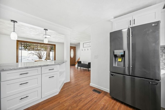 kitchen featuring visible vents, white cabinetry, light stone countertops, light wood-type flooring, and stainless steel fridge with ice dispenser