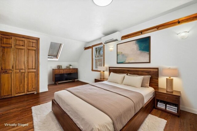 bedroom featuring a wall unit AC, vaulted ceiling with skylight, baseboards, and dark wood-type flooring