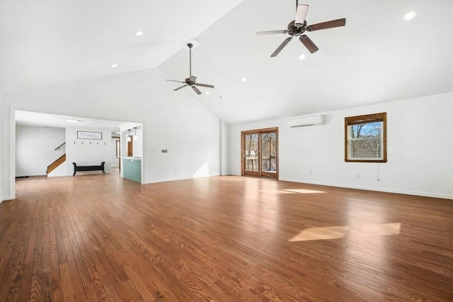 unfurnished living room with baseboards, a ceiling fan, hardwood / wood-style floors, a wall mounted air conditioner, and high vaulted ceiling