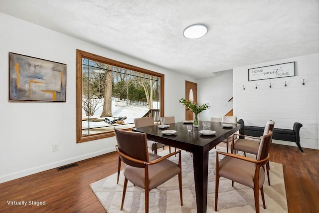 dining space with baseboards, visible vents, stairway, wood finished floors, and a textured ceiling