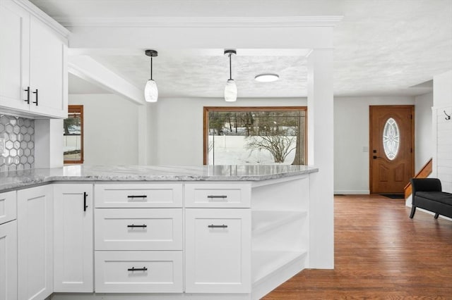 kitchen with dark wood-style floors, white cabinets, decorative light fixtures, and light stone countertops