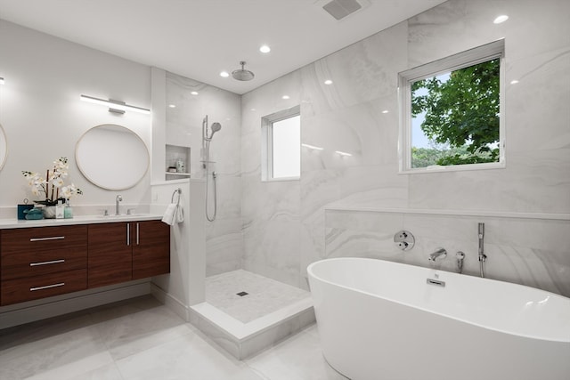 bathroom with tile walls, shower with separate bathtub, and vanity