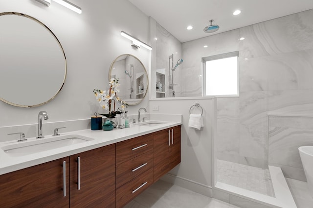 bathroom featuring a tile shower, vanity, and tile patterned floors