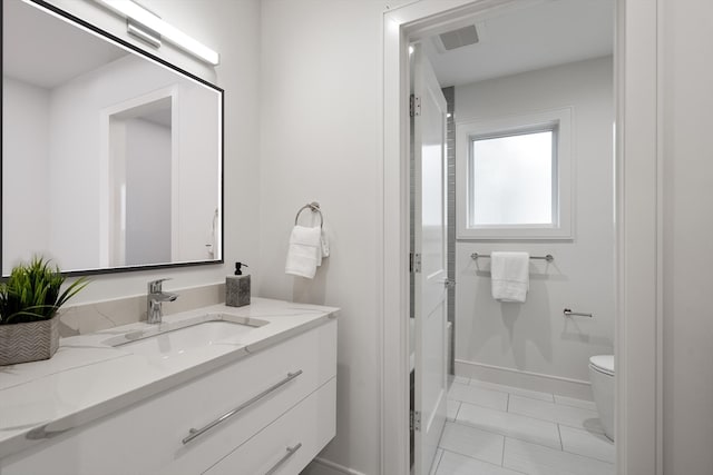 bathroom featuring vanity, toilet, and tile patterned floors