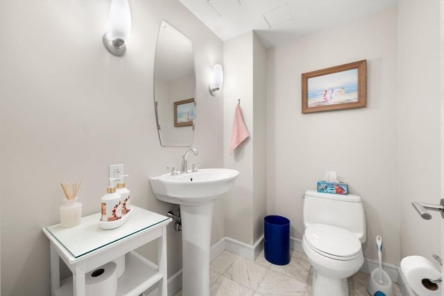 bathroom with baseboards, marble finish floor, and toilet