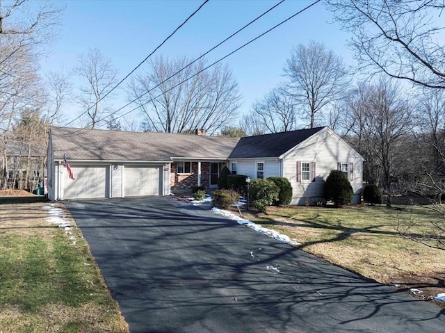 single story home featuring a front lawn and a garage