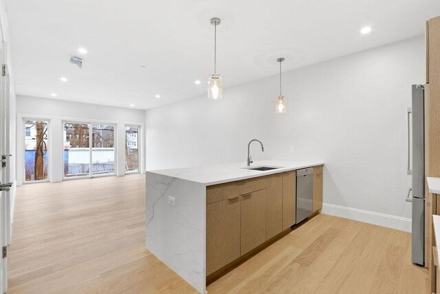 230 Washington St Unit 11, Boston, MA 02135 - kitchen featuring a peninsula, light wood-style flooring, a sink, open floor plan, and dishwasher