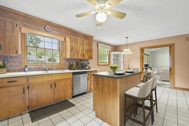 9 Divittorio Dr, Milford, MA 01757 - kitchen featuring stainless steel dishwasher, a sink, decorative backsplash, a kitchen island, and a breakfast bar area
